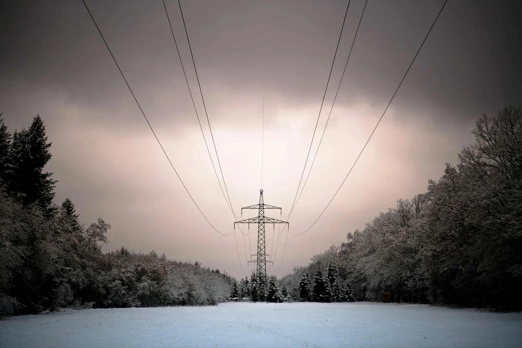 A transmission pylon in a snow-covered landscape