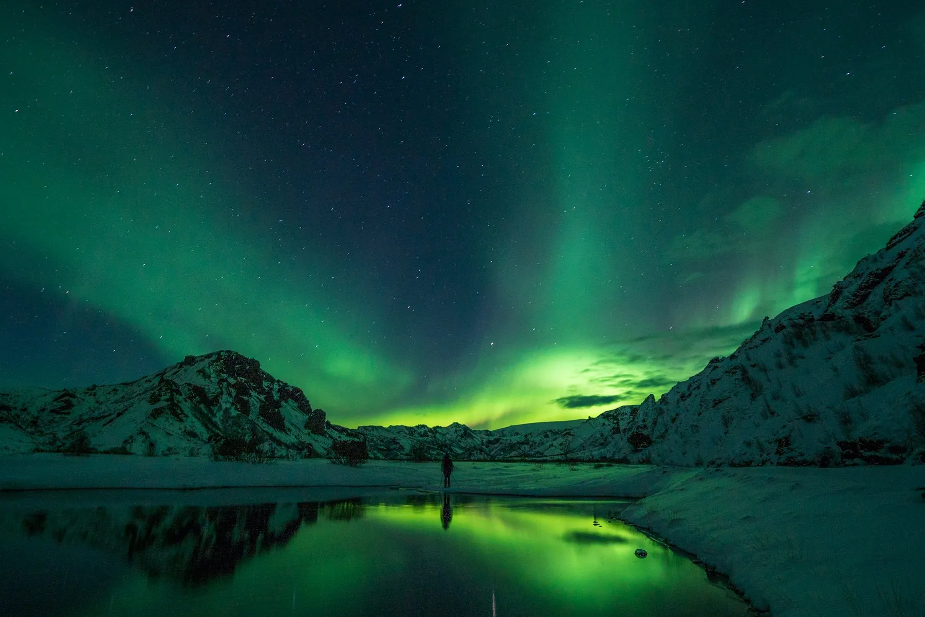 Aurora borealis over a snow-covered mountain in Iceland
